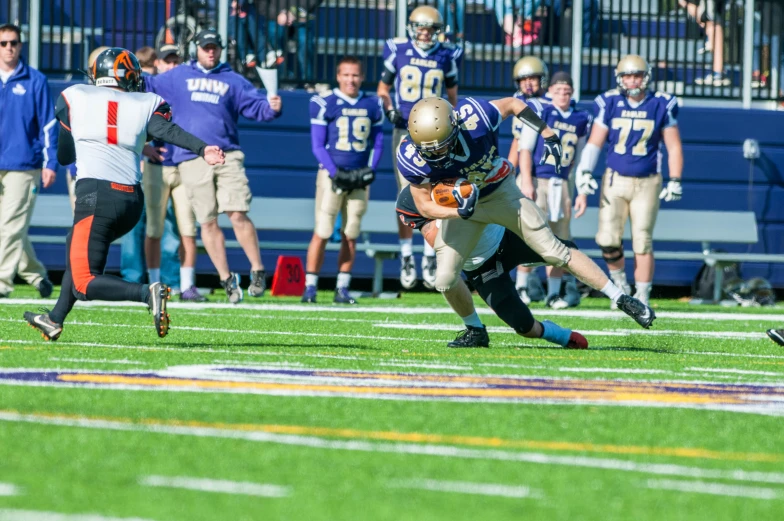 a man in blue and white football uniform dives for the ball