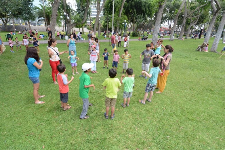 several people stand around as one plays with a frisbee