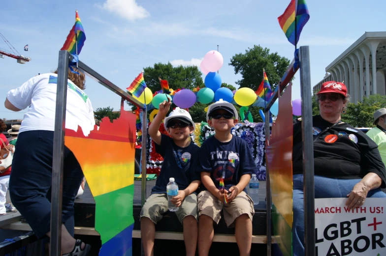 two boys wearing sun hats on their float in the parade