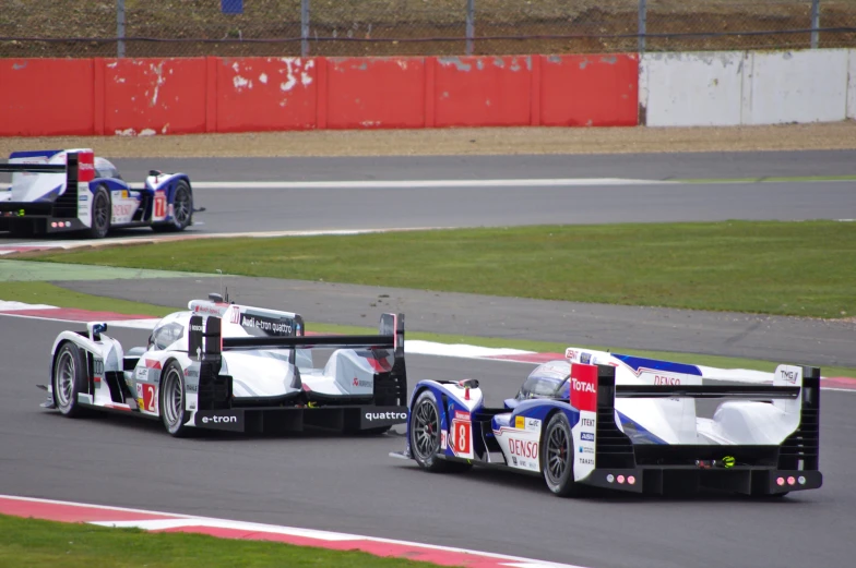 two race cars driving down the road