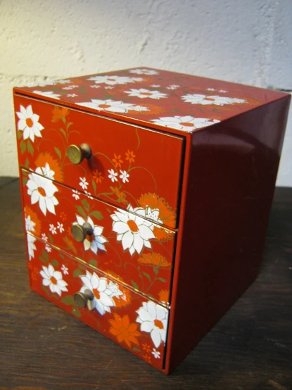 an old wooden cabinet painted in red and white flowers