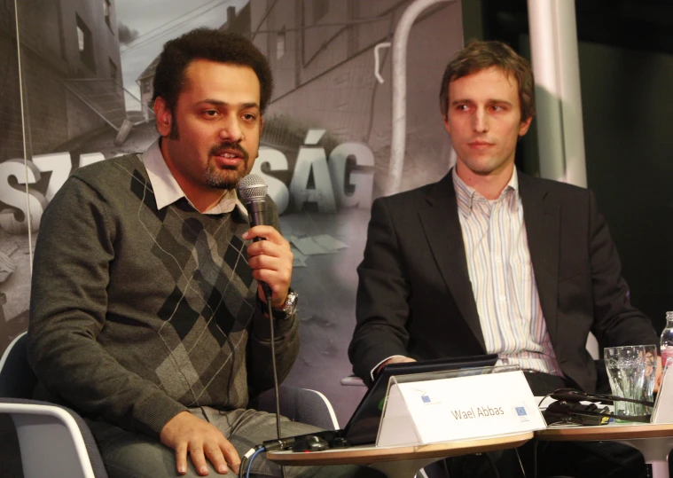 two men are sitting in front of microphones