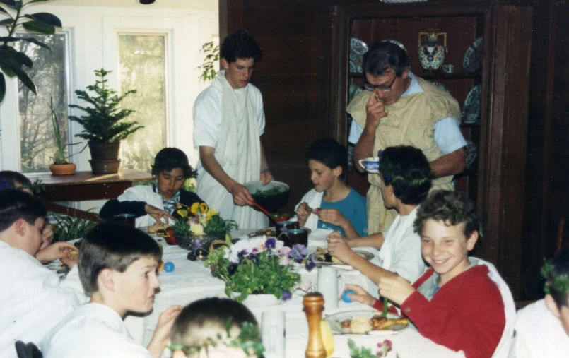 a group of children sitting around a dinner table