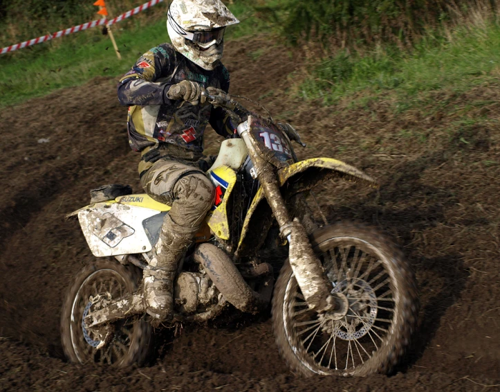 a dirt bike rider in full gear and mud