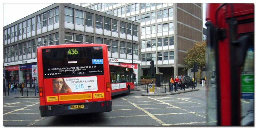 two buses side by side, on a city street