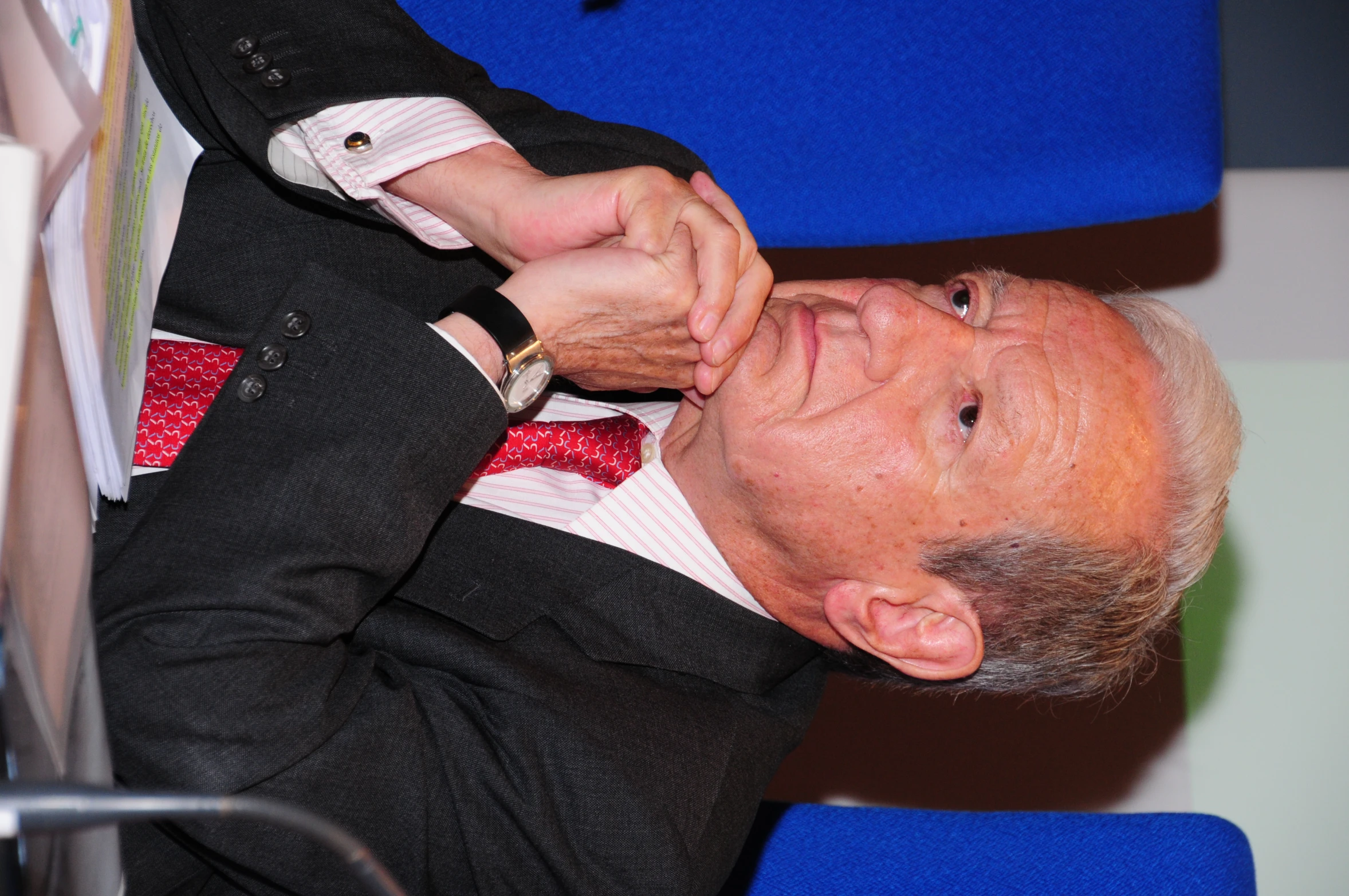 a man in a suit and tie sitting at a desk