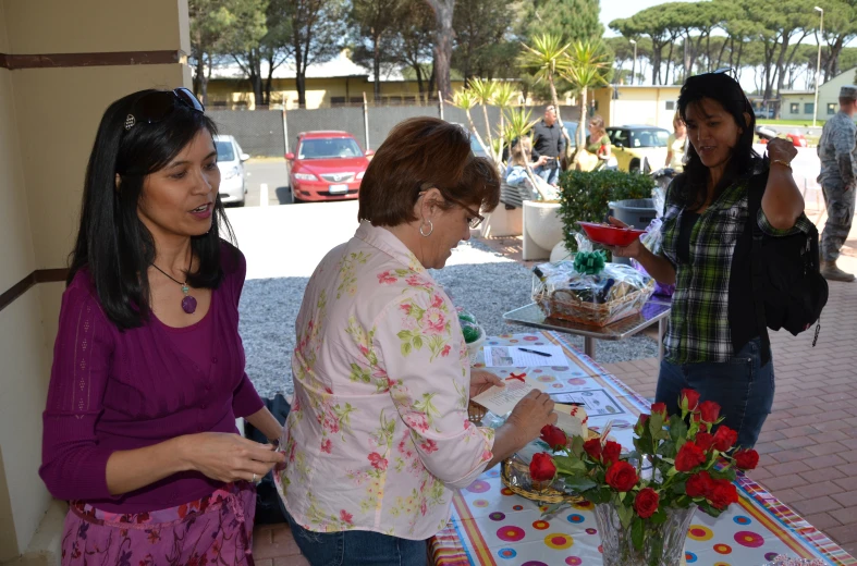 some women are standing in front of a table with cake