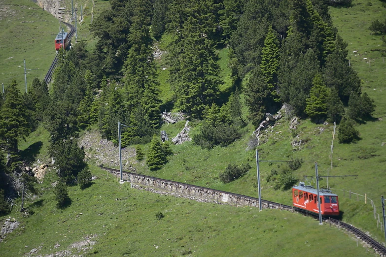 a small red train going through the mountain side
