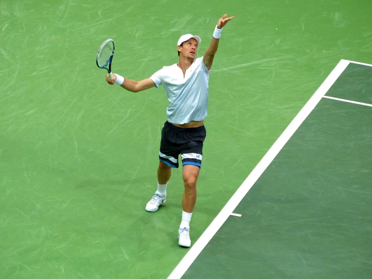 a man is hitting a tennis ball on a green court