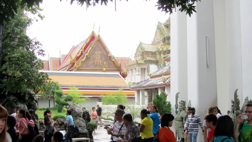 people standing around in an enclosed courtyard near a tree