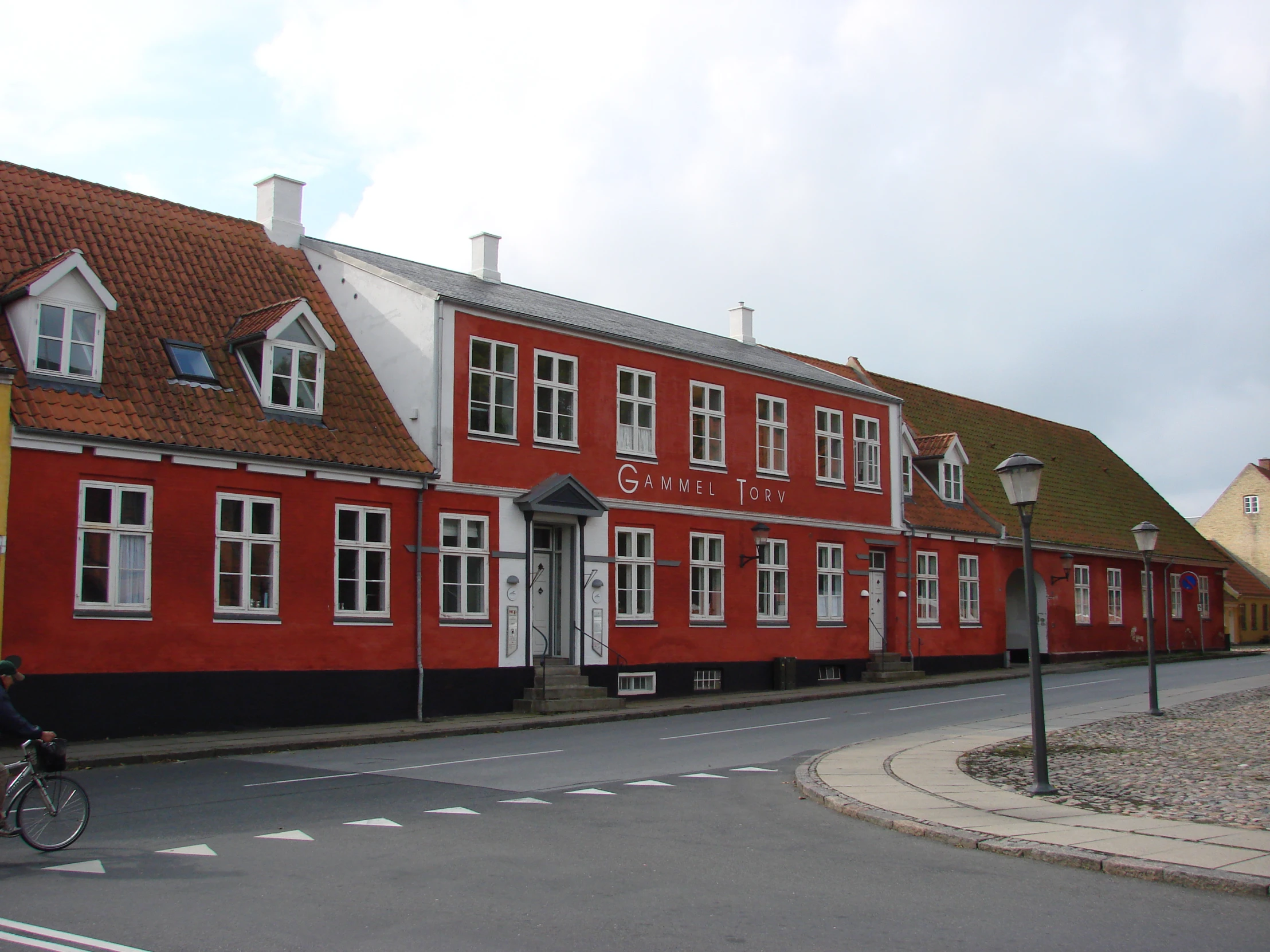 person riding bike on street in front of a building