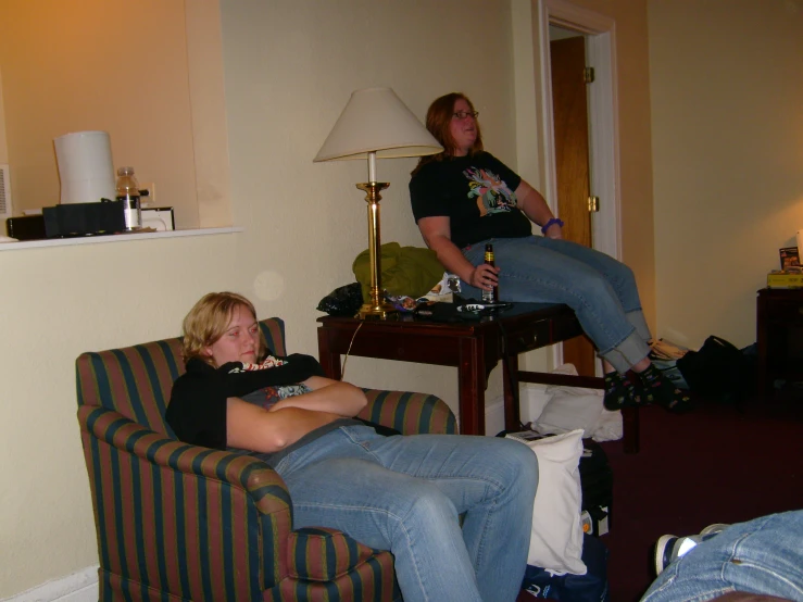 two women in the same room sitting and playing video games