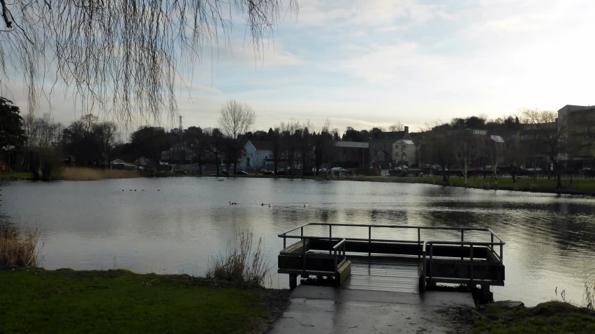 a lake with boats in the water and a house on the other side