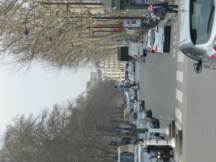 a lot of cars on a street and people walking along the side