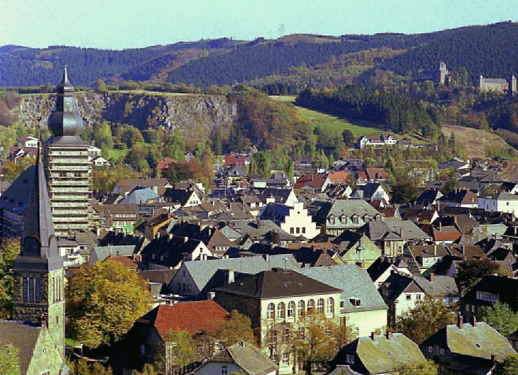 a town with many buildings and trees on a mountain side