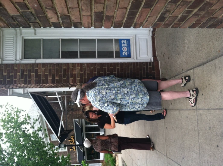 a group of people standing next to each other on a sidewalk