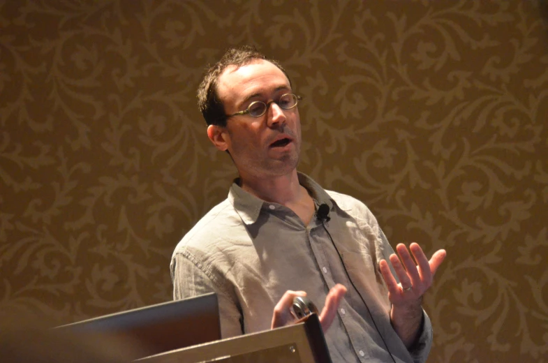 a man that is standing up wearing glasses