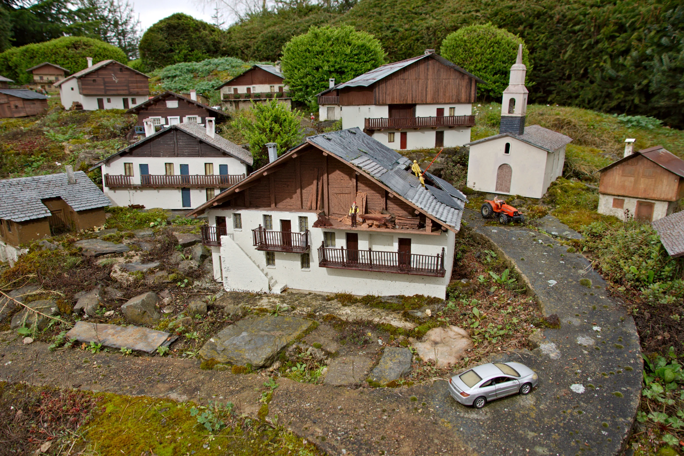 toy car in front of miniature wooden buildings