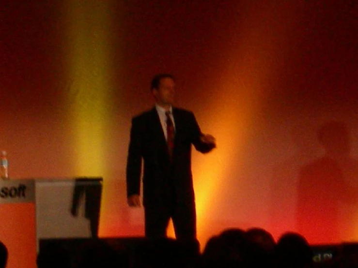 a man in a suit speaking to the crowd