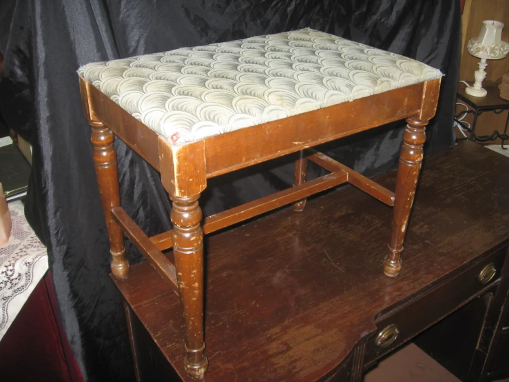 a small brown table with an old wooden seat