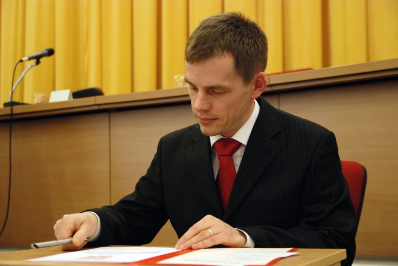 a man is sitting at a desk working on paperwork