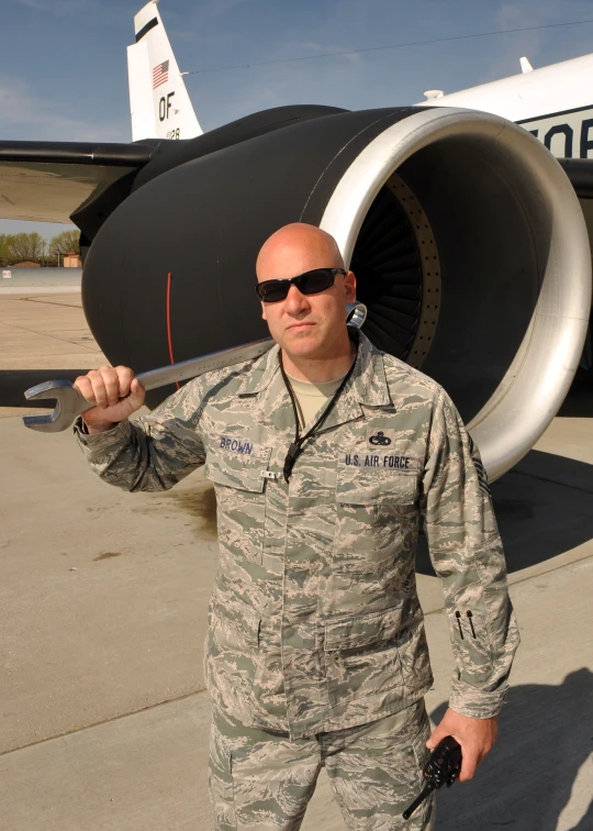 a man in a camouflage uniform holding a plane propeller