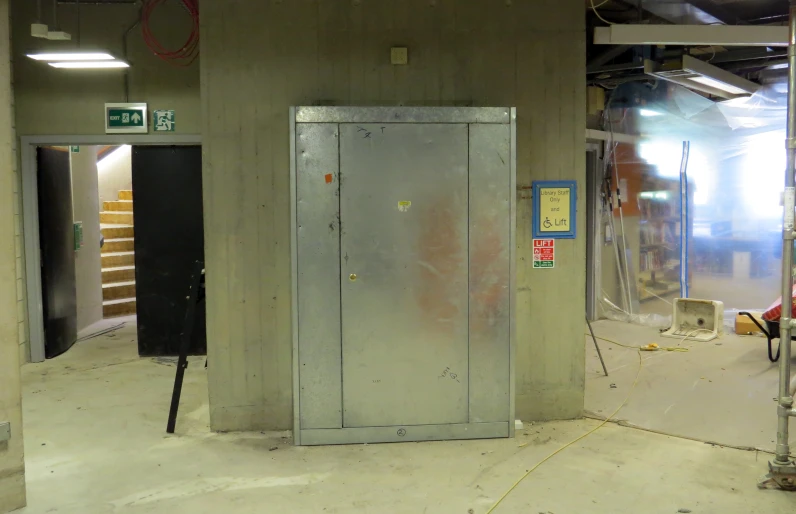 a steel restroom stall with an exit way