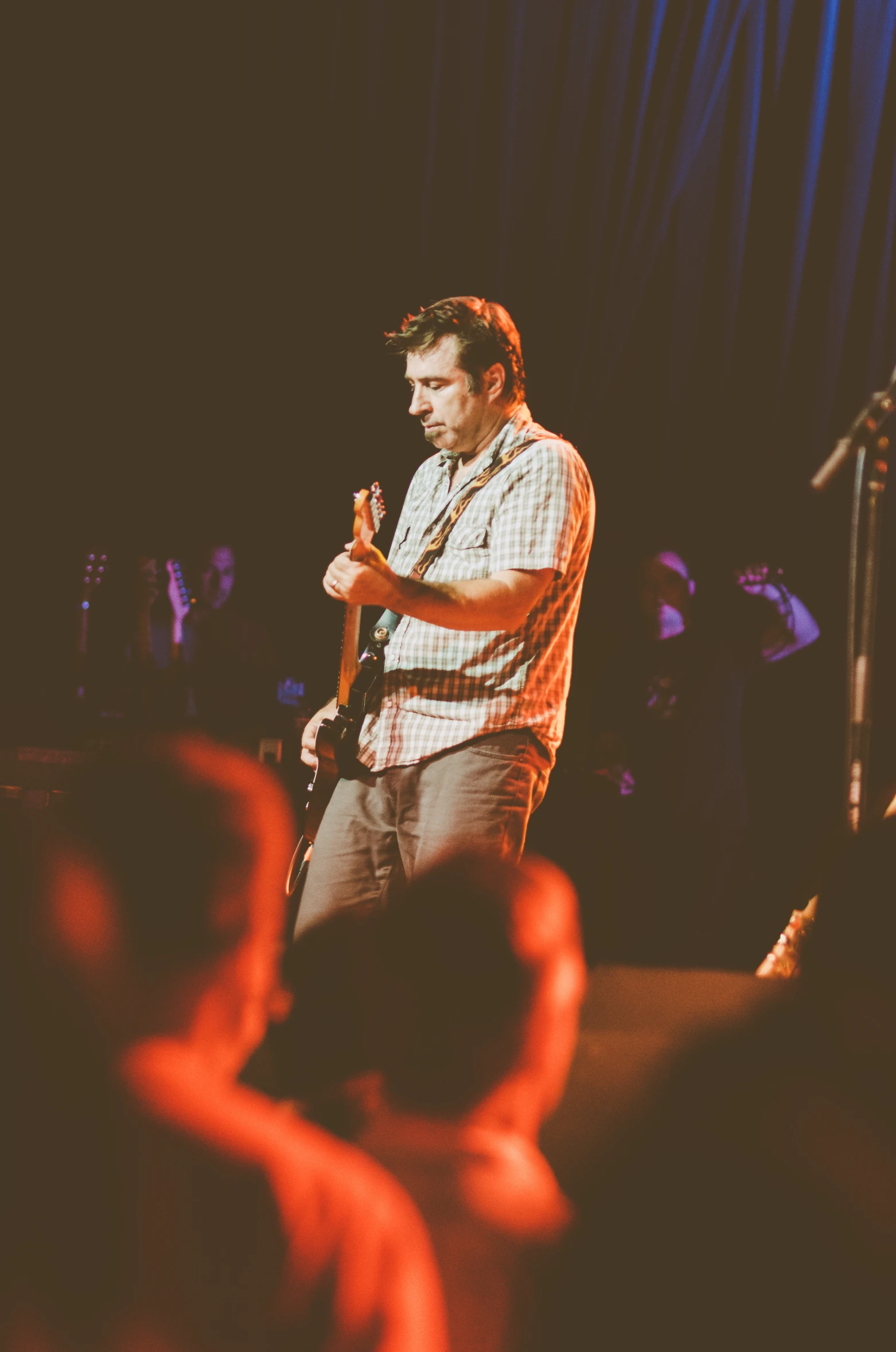 a man stands on a stage in front of an audience while holding a microphone