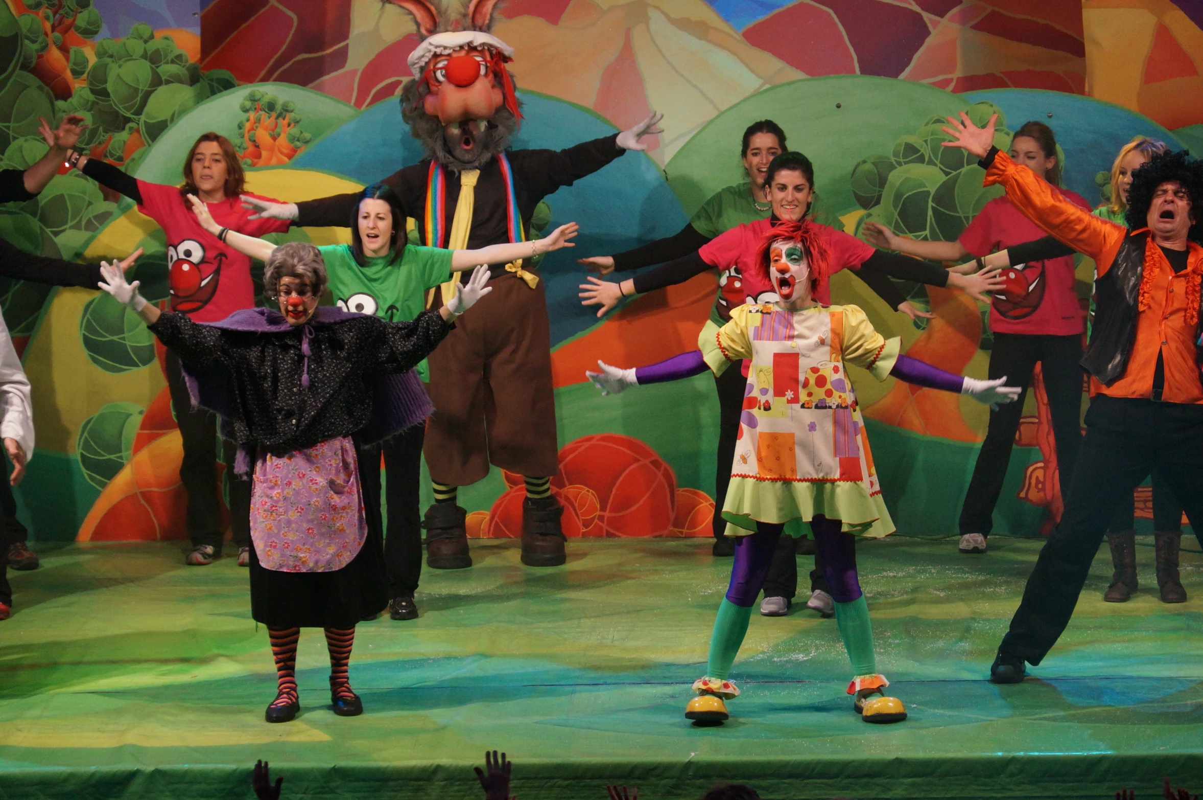 the group of children perform on stage with clown costumes