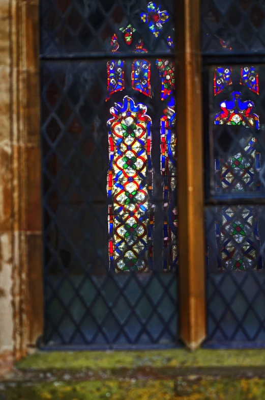 a pair of stained glass window with a clock in the background