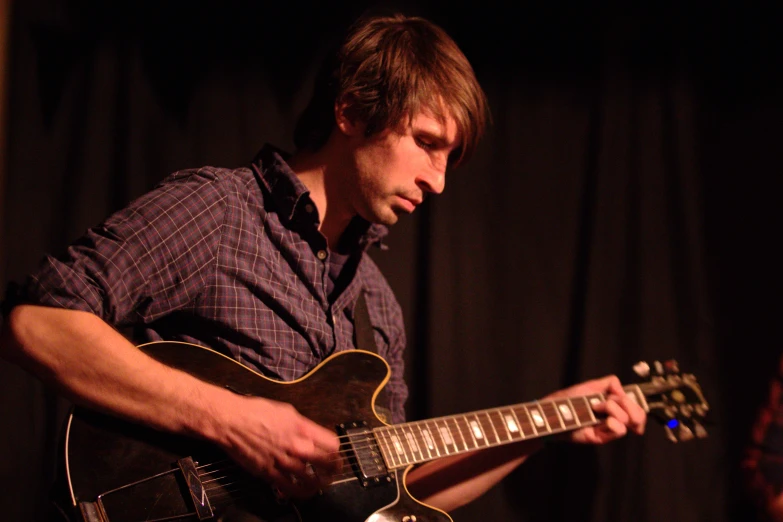 a man holding a guitar at the microphone