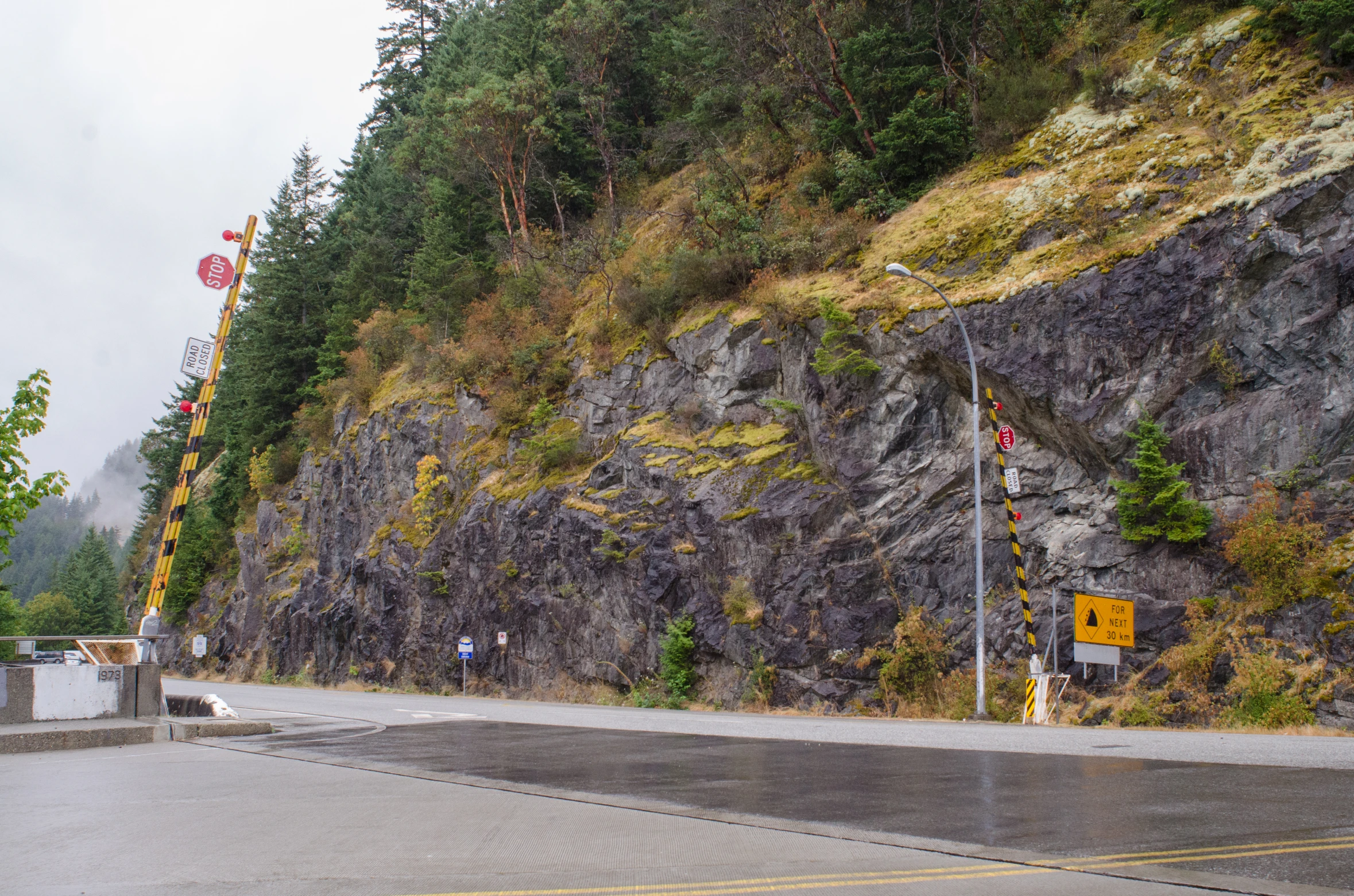 an empty lot near the side of a mountain with many signs