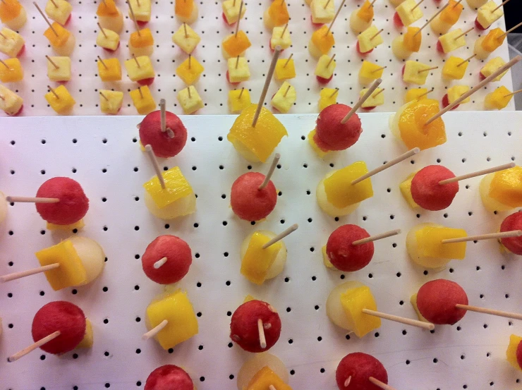 candy coated apples and bananas arranged on a white tray