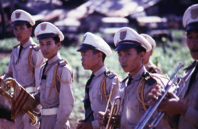 the men are wearing uniforms that include hats and holding guns