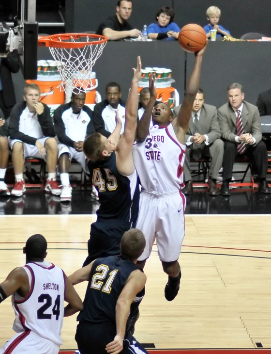 two men playing basketball, jumping up for the ball