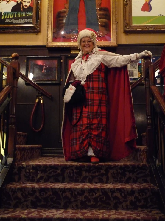 a woman dressed in costume standing at the top of some stairs