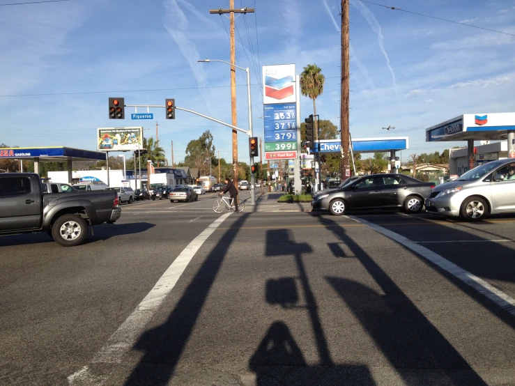 some cars at a gas station with people walking through