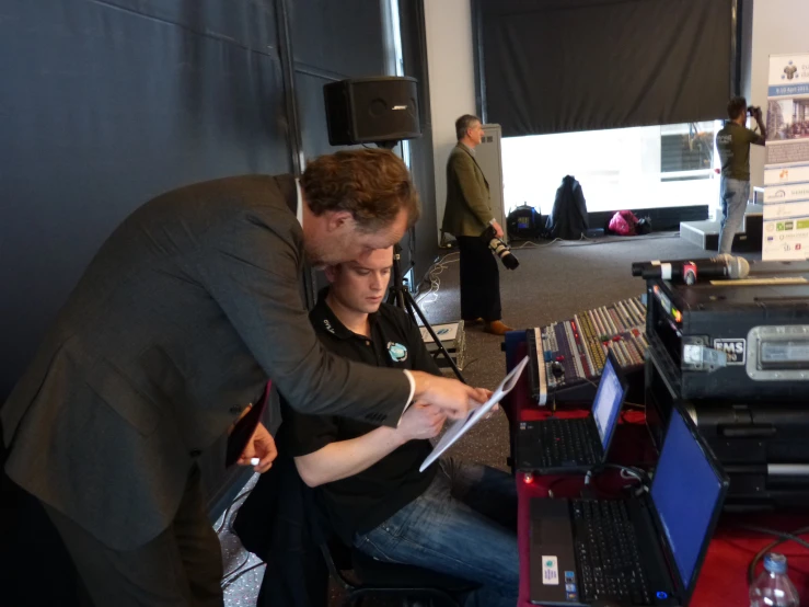 man and child sitting by the table with computers on it