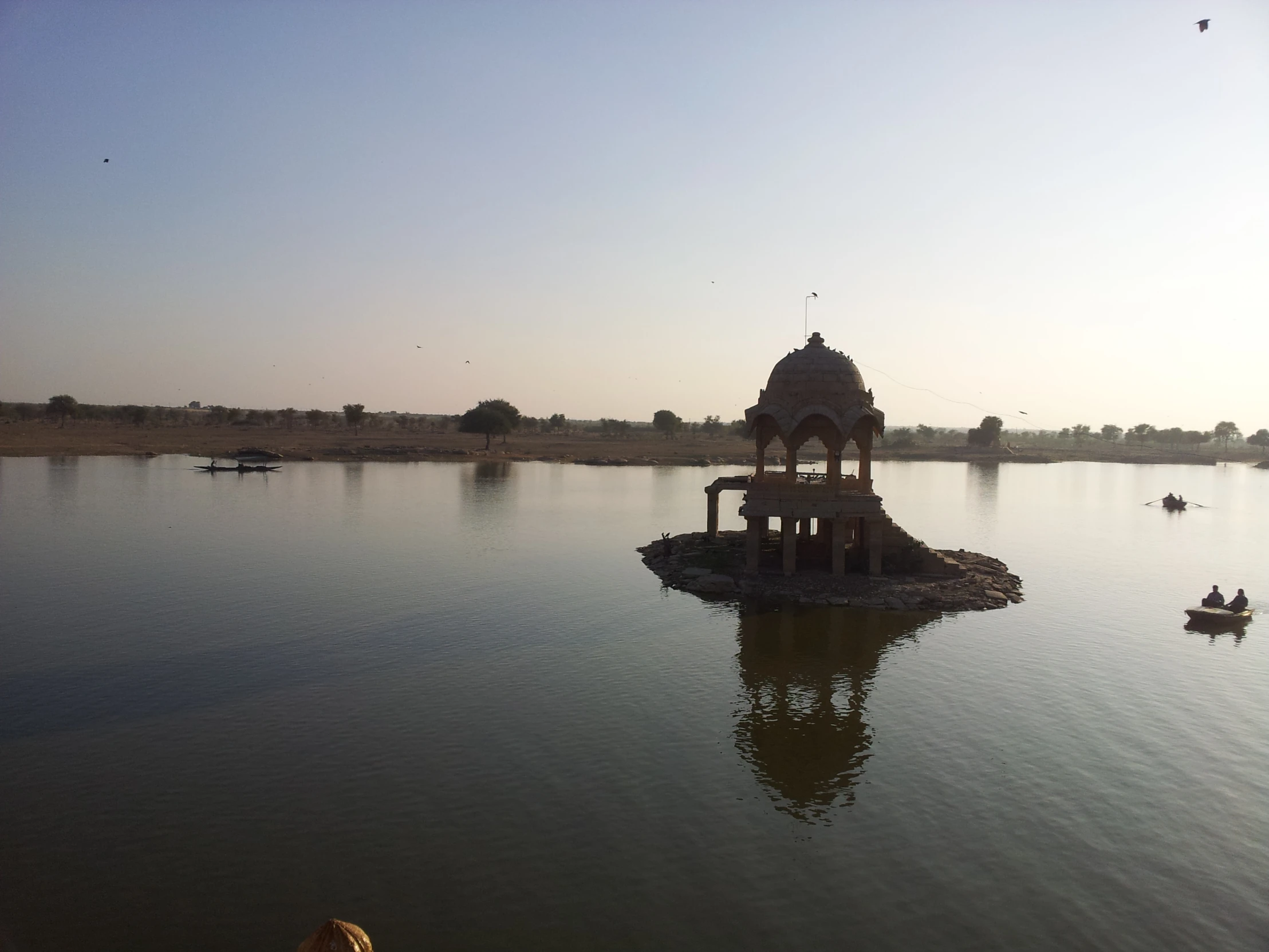 water palace, lake and boats in it, with kites flying above