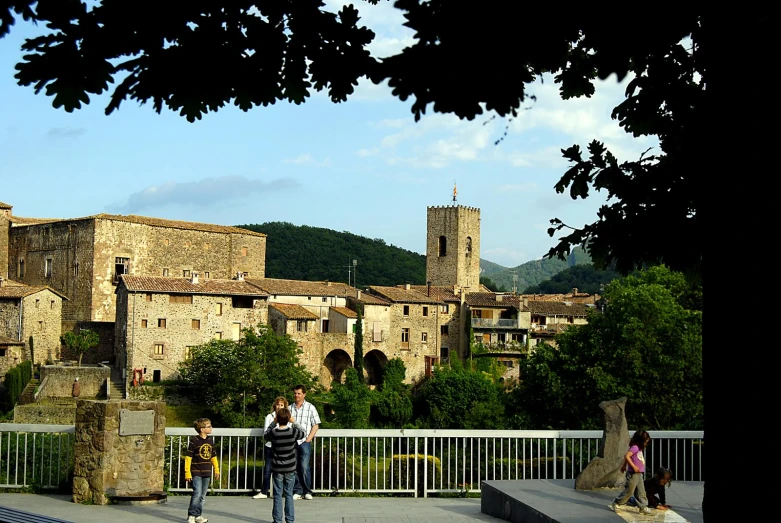 a group of people riding down a bridge near an old city