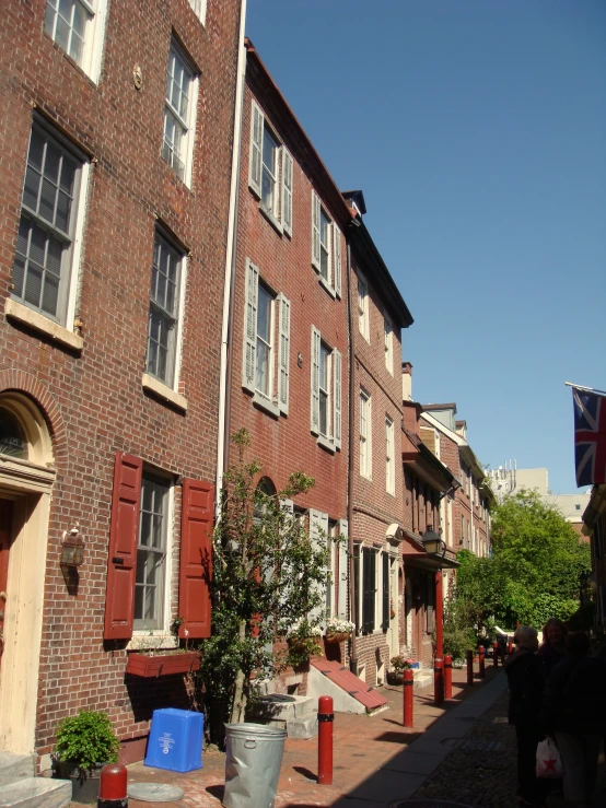 a row of brick apartment buildings with a flag on the roof
