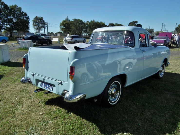 a large blue and white truck parked on a grass field