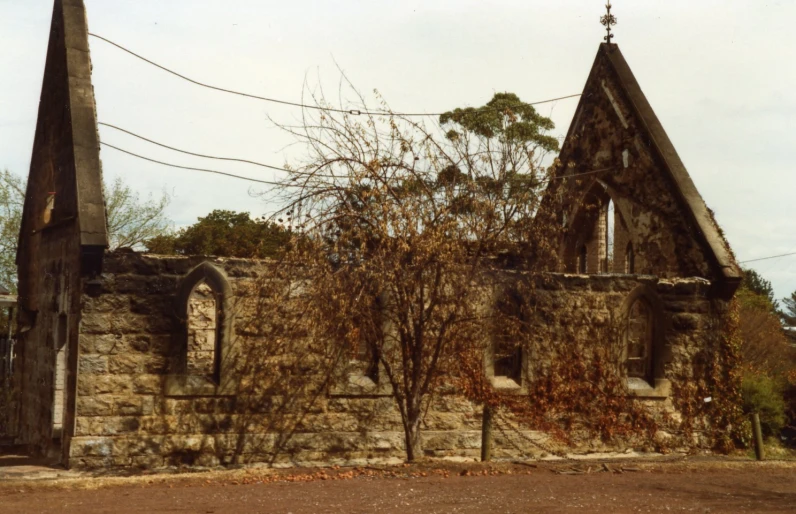 an old stone church sits next to some trees