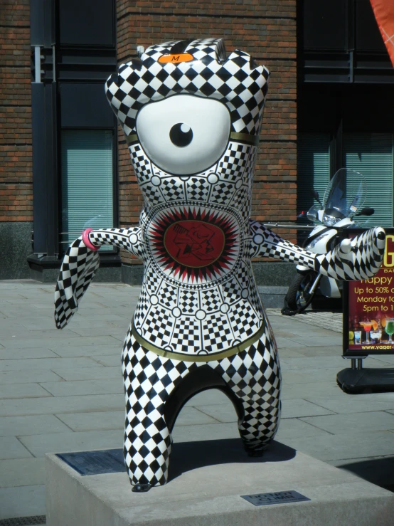 a large, patterned sculpture in the shape of a bear stands on its feet on a sidewalk