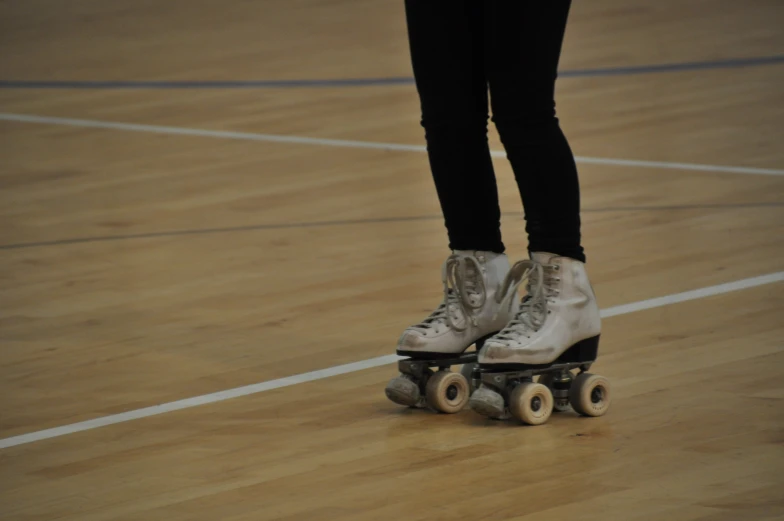 a person with roller blades on a wooden floor