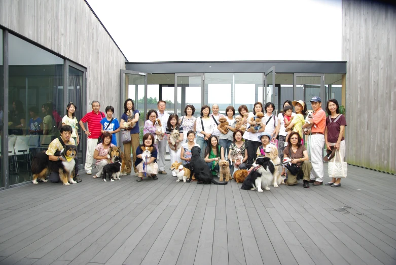 large group of people posing for a group po with their dogs