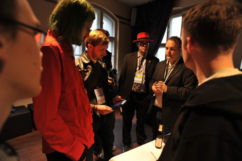 a group of people in front of windows looking at papers and drinks