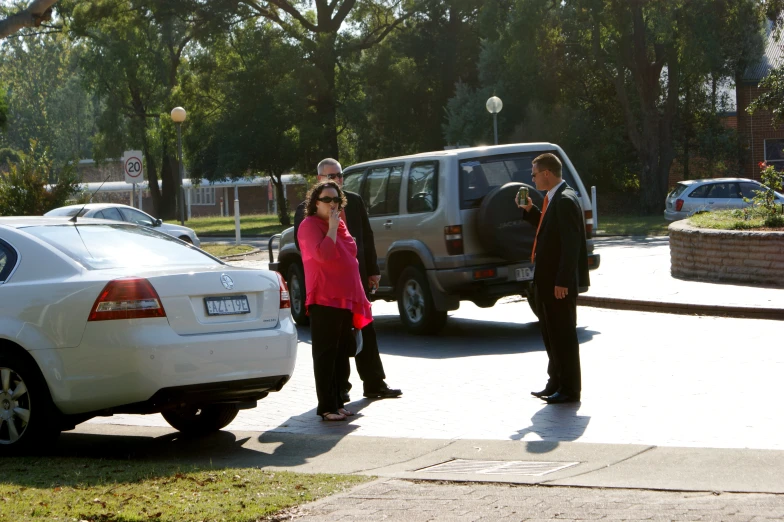 a man in a suit and woman standing on the sidewalk