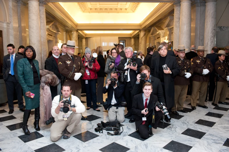 a group of people standing in front of a building with camera equipment