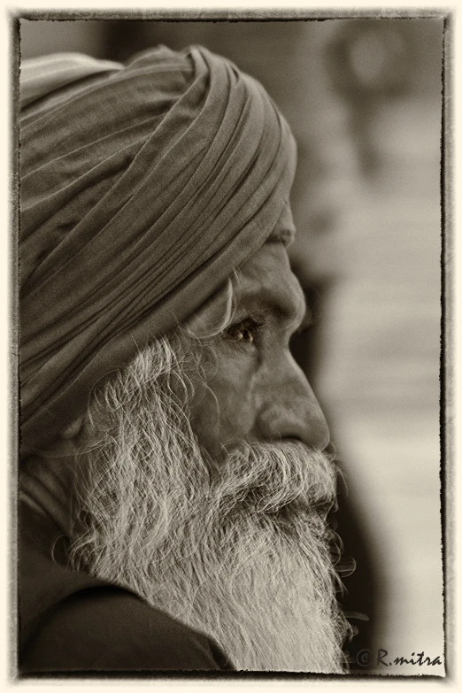 an old man with a large beard wearing a turban